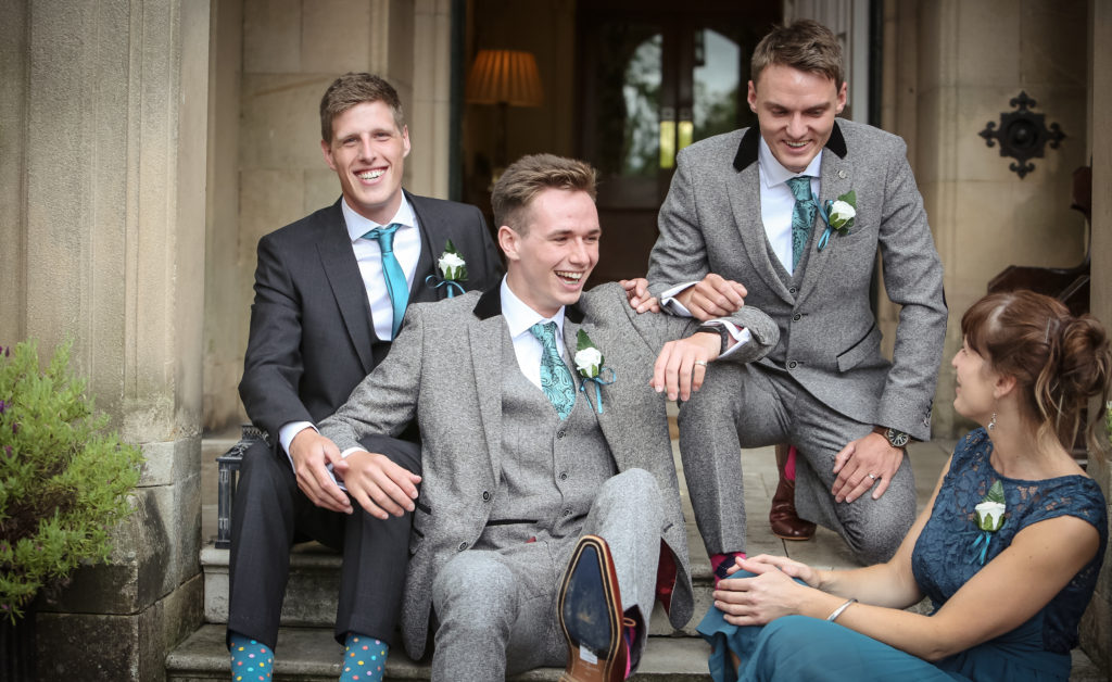 playful gay couple and best man shot laughing