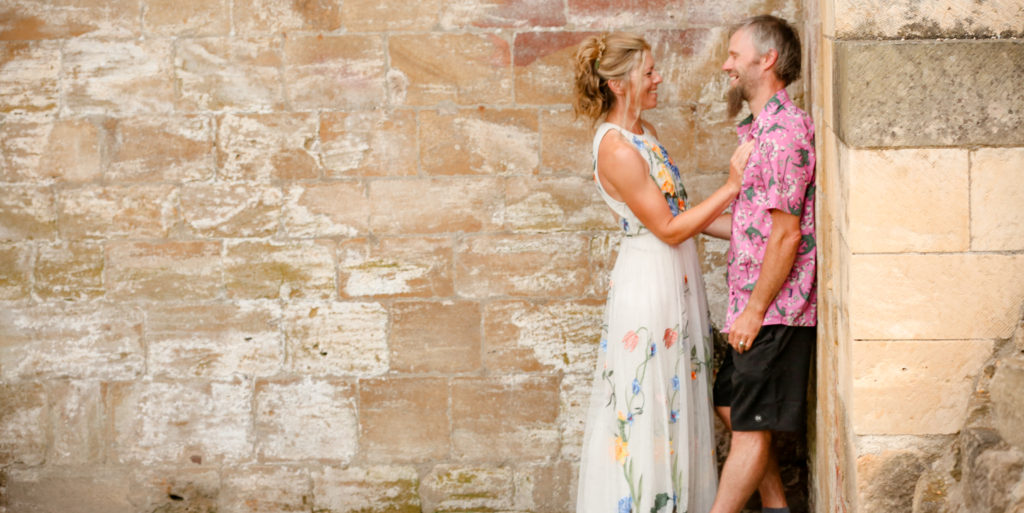 Wedding photographer Nottingham capturing natural bride and groom portrait against wall