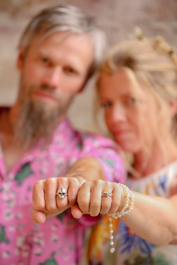 bride and groom out of focus with rings in focus.