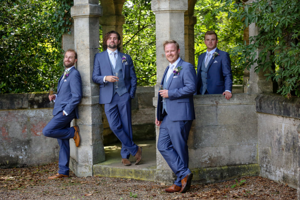 posed groom and groomsmen shot near statues. vogue
