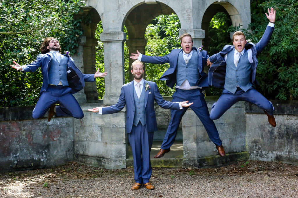 Groom and groomsmen shot, jumping in air