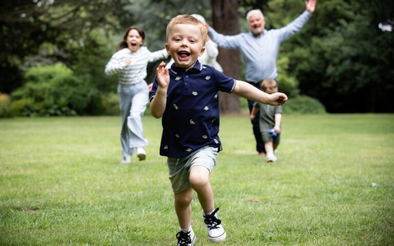 grandson being chawed by grandparents on family photo shoot