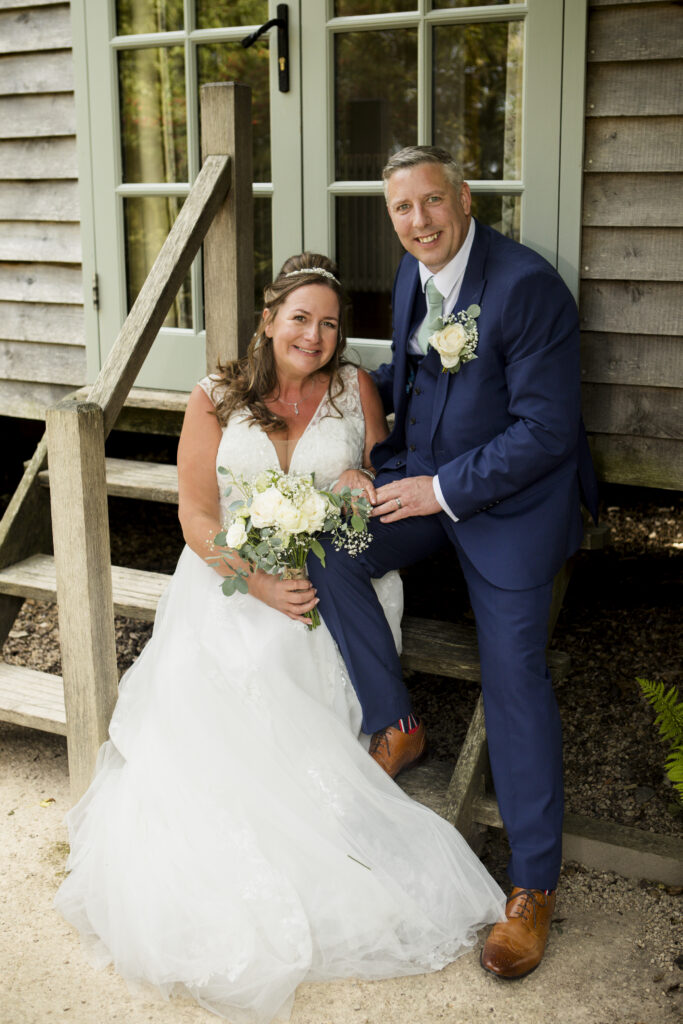 Bride and groom against shepherds hut in Carriage Hall, Plumtree