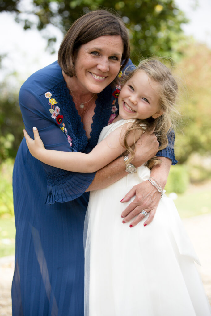 loving image of bridesmaid flower girl and mum hugging