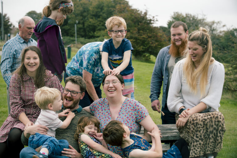 extended family on picnic bench, messing about