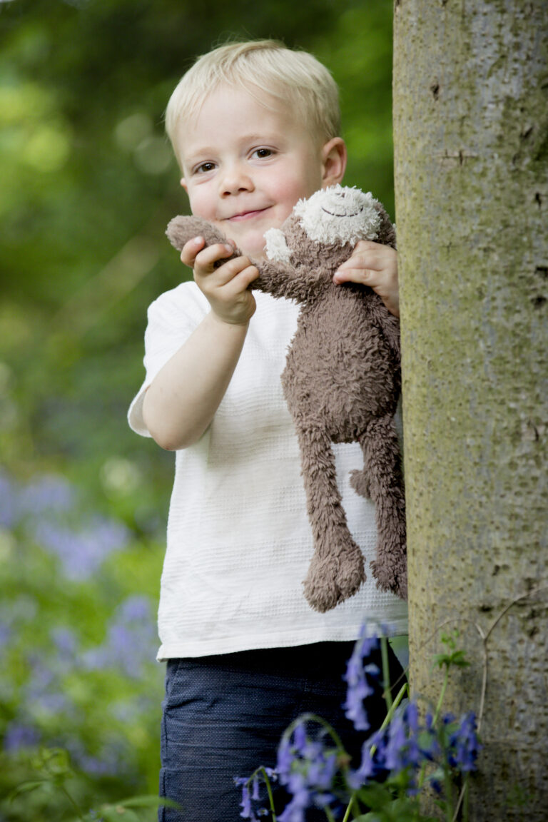 boy waving teddy to camera