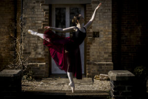 Ballet dance, in pose with arm outstretched in point shoes @agentlemensresidence in background