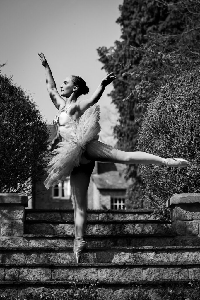 @agentlemansresidence house in the background. Ballet dance in arabesque. Black and white image.
