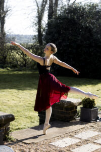 Ballet dance, in pose with arm outstretched in point shoes @agentlemensresidence in background