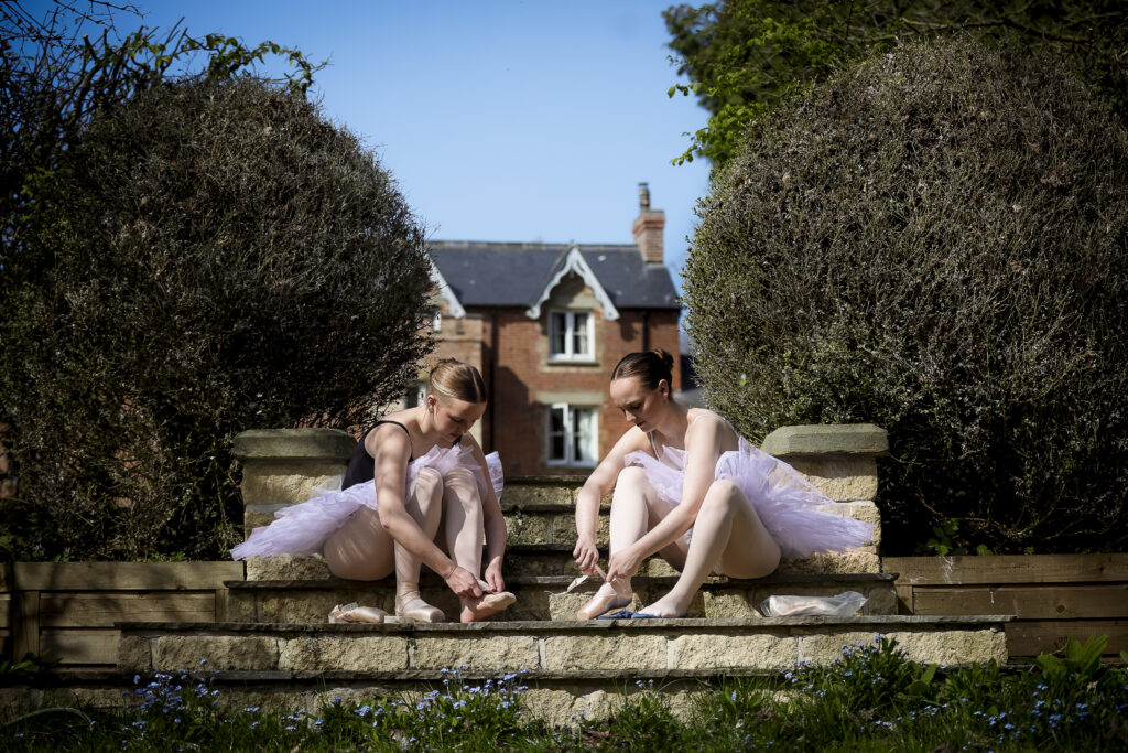 @agentlemansresidence house in the background. 2 ballet dancers teeing shoes