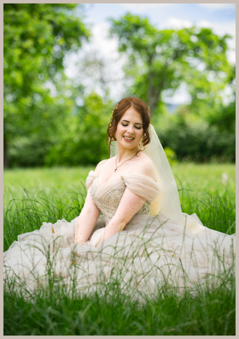 Bride in an ivory wedding dress and veil seated in a meadow, captured by a wedding photographer in Nottinghamshire